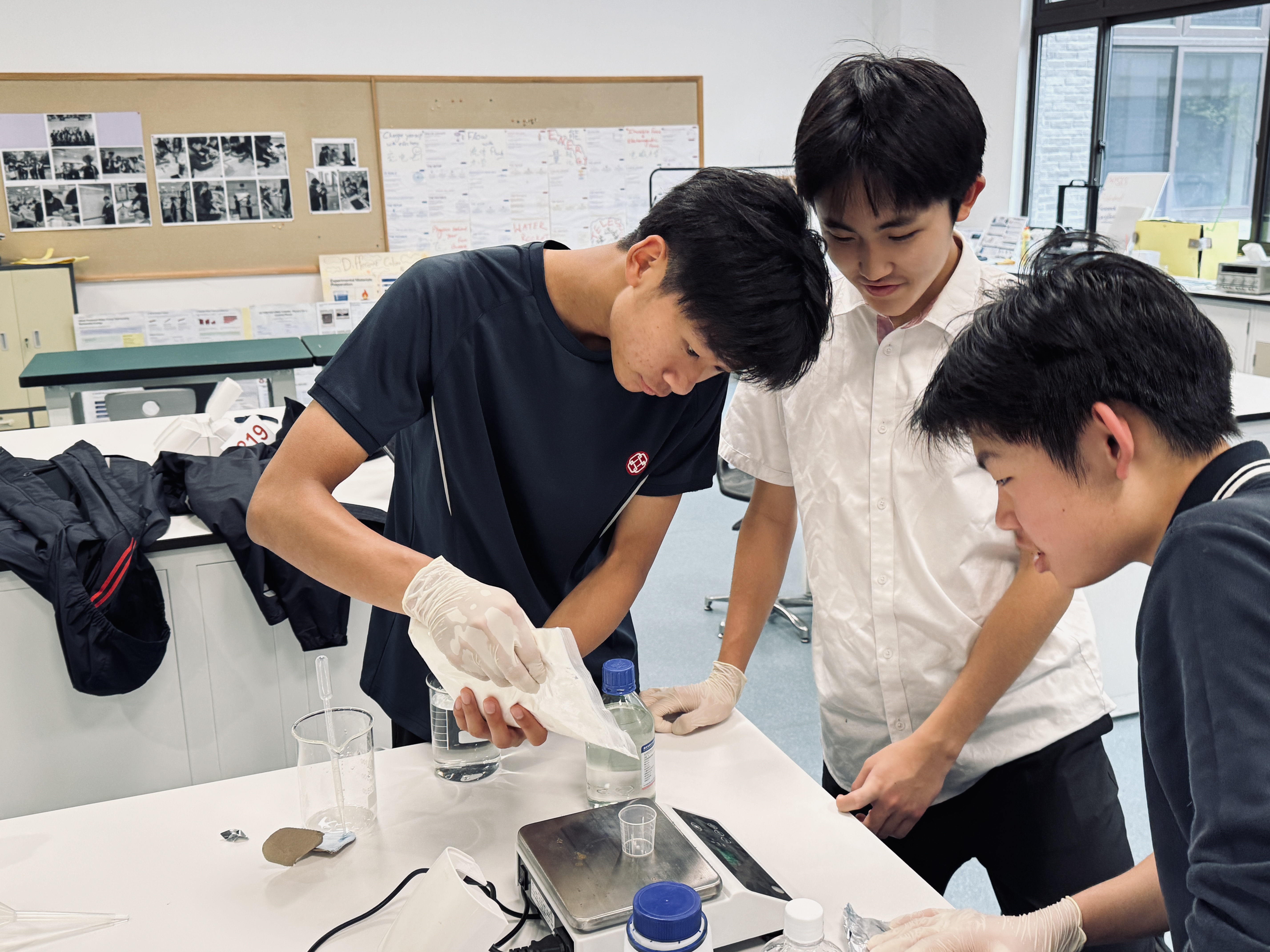 Students measuring specimen mass after coating layer using balance